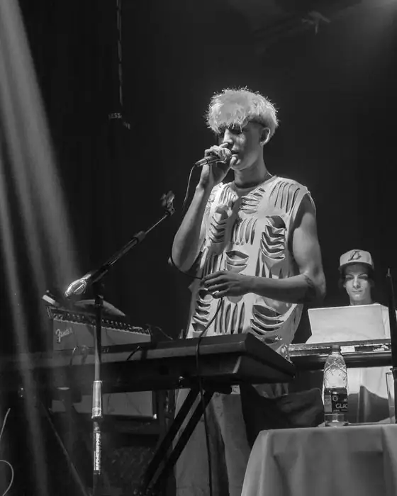 Borja cantando en vivo junto a los teclados, en blanco y negro